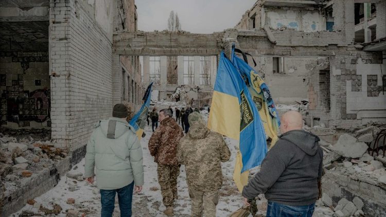 Soldados ucranianos e parentes de soldados mortos caminham com bandeiras nacionais até os locais dos ataques aéreos e os lugares onde os soldados morreram, durante um evento dedicado à memória dos soldados ucranianos mortos no aniversário dos bombardeios mortais, em Kharkiv, em 2 de março de 2025, em meio à invasão russa da Ucrânia. Nas primeiras semanas da invasão em grande escala, aeronaves russas bombardearam maciçamente a cidade de Kharkiv, incluindo fortalezas militares. Em 2 de março de 2022, vários ataques aéreos foram realizados no ponto de implantação permanente da 113ª Brigada de Defesa Territorial das Forças Armadas da Ucrânia, resultando na morte de 16 soldados. No terceiro aniversário, 2 de março de 2025, uma pedra memorial foi erguida em homenagem aos mortos perto do local dos bombardeios. (Foto de Ivan SAMOILOV / AFP)