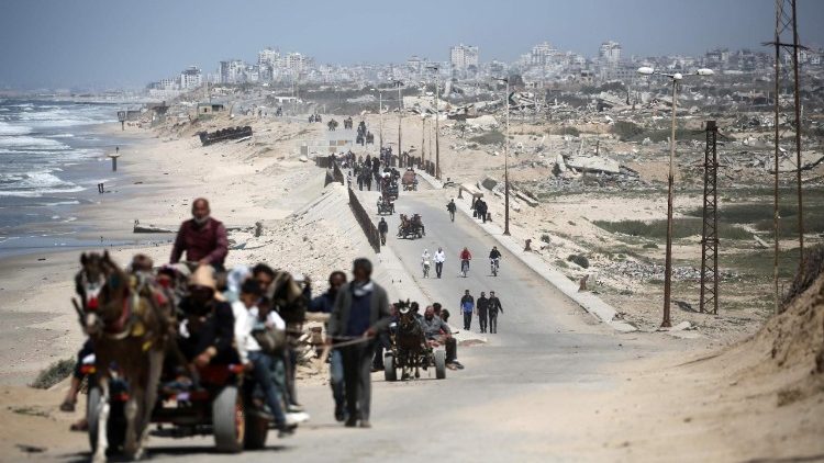 Displaced Palestinians transport their belongings along Gaza's coastal road