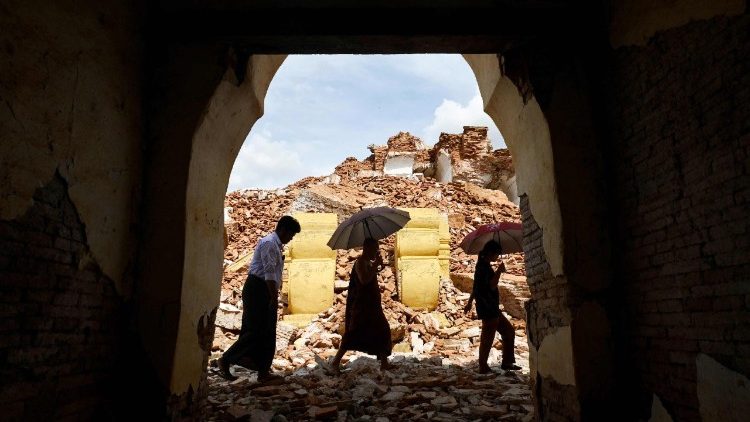 People walk past debris in the damaged Me Nu Brick monastery in Inwa on the outskirts of Mandalay on April 12, 2025, following the devastating March 28 earthquake