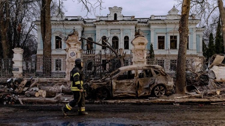 Um socorrista ucraniano caminha perto de um carro incendiado em frente a um prédio danificado no local de um ataque com mísseis em Sumy, nordeste da Ucrânia, em 13 de abril de 2025, em meio à invasão russa da Ucrânia. Autoridades ucranianas disseram que dois mísseis balísticos atingiram o centro da cidade no nordeste, perto da fronteira com a Rússia, matando pelo menos 34 pessoas, enquanto líderes europeus e americanos condenavam um dos ataques mais mortais em meses. (Foto de Roman PILIPEY / AFP)