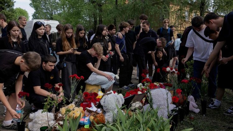 Amigos e colegas de classe do jovem de 17 anos que morreu após um ataque com míssil russo depositam flores em luto em Kiev, em 25 de abril de 2025, em meio à invasão russa na Ucrânia. (Foto de Tetiana DZHAFAROVA / AFP)