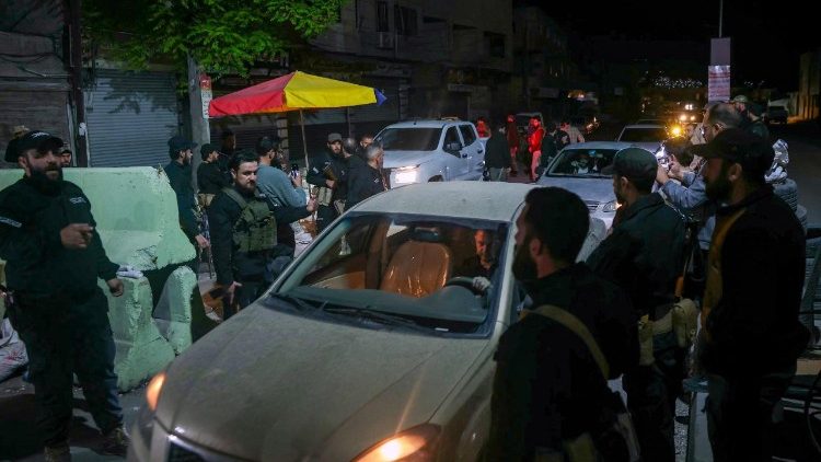 Membri delle forze di sicurezza siriane di guardia a un checkpoint nei pressi della capitale Damasco