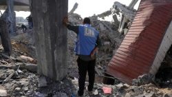 A UN worker stands amid the rubble of an UNRWA school-turned-shelter, heavily damaged overnight by Israeli strikes 