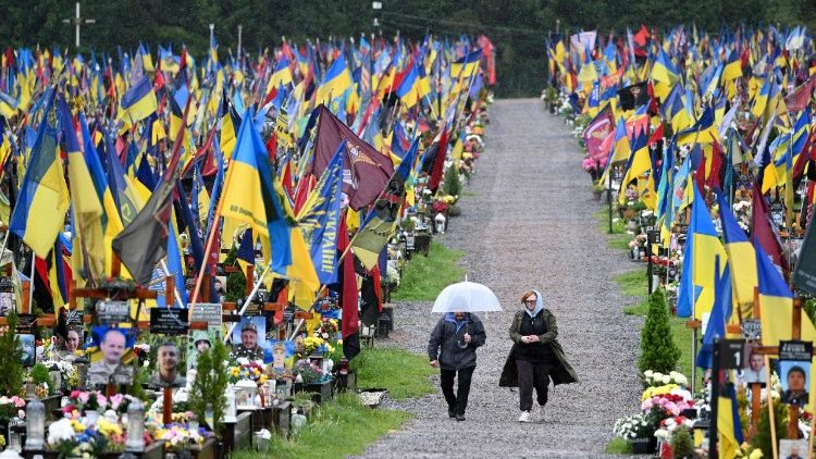 Pessoas visitam o cemitério militar de Lychakiv, em Lviv, em 15 de maio de 2025, em meio à invasão russa da Ucrânia. (Foto de YURIY DYACHYSHYN / AFP)