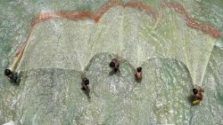 Pakistanische Fischer werfen am Indus das Netz aus