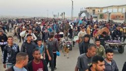Sfollati palestinesi di ritorno dalla distribuzione di aiuti a Rafah, dopo l'attacco israeliano