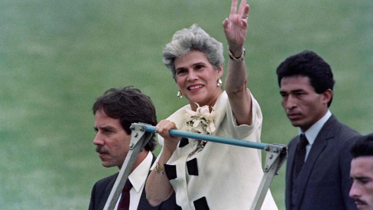 A presidente nicaraguense Violeta Chamorro (C) acena para a multidão ao chegar ao Estádio Nacional de San José, em 8 de maio de 1990, para participar da cerimônia de posse do presidente eleito da Costa Rica, Rafael Calderón
