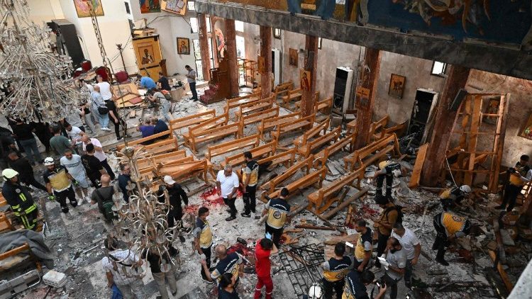Pessoas e equipes de resgate inspecionam os danos no local de um suposto ataque suicida na igreja de Santo Elias, na área de Dwelaa, em Damasco, em 22 de junho de 2025. A mídia estatal síria noticiou um ataque suicida contra uma igreja de Damasco em 22 de junho, que deixou vítimas. Correspondentes da AFP no local viram socorristas transportando pessoas do local. (Foto de LOUAI BESHARA / AFP)