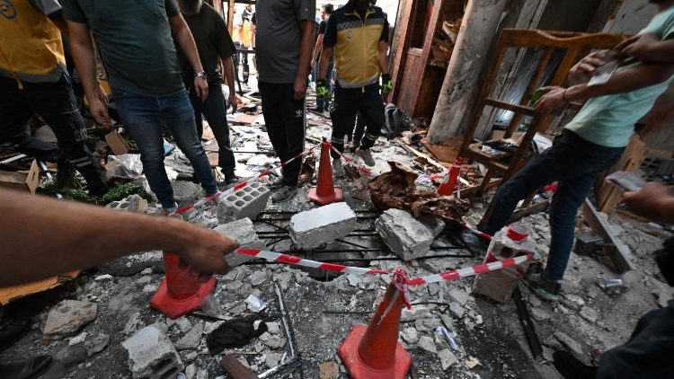 Pessoas e equipes de resgate inspecionam os danos no local de um suposto ataque suicida na igreja de Santo Elias, na área de Dwelaa, em Damasco, em 22 de junho de 2025. A mídia estatal síria noticiou um ataque suicida contra uma igreja de Damasco em 22 de junho, que deixou vítimas. Correspondentes da AFP no local viram socorristas transportando pessoas do local. (Foto de LOUAI BESHARA / AFP)