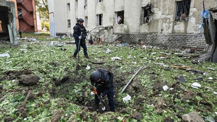 Policiais removem os destroços resultantes de um ataque de drone russo perto de um prédio residencial danificado em Kharkiv, em 7 de julho de 2025, em meio à invasão russa na Ucrânia. Ataques russos mataram pelo menos quatro pessoas e feriram mais de 30 em toda a Ucrânia durante a noite, disseram autoridades regionais em 7 de julho. (Foto de SERGEY BOBOK / AFP)
