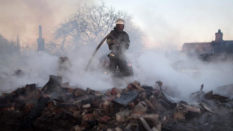 Um bombeiro combate um incêndio após bombardeios destruírem várias casas no distrito de Kuibishevskiy, perto do aeroporto, na cidade de Donetsk, no leste da Ucrânia, em 20 de novembro de 2014, enquanto o fogo de artilharia continua a abalar o bastião rebelde pró-Rússia no leste da Ucrânia. Em 9 de julho de 2025, um tribunal superior europeu decidiu que a Rússia cometeu violações de direitos humanos ao apoiar separatistas anti-Kiev no leste da Ucrânia a partir de 2014, ao derrubar o voo MH17 naquele ano e à invasão da Ucrânia em 2022. (Foto de Menahem KAHANA / AFP)