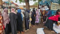 विस्थापित सूडान वासी खाद्य सामग्री के लिए कतार में खड़े हैं