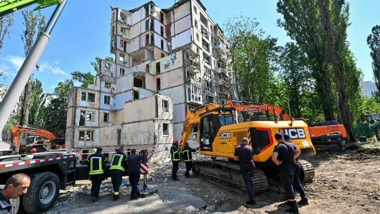 Equipes de resgate trabalham do lado de fora de um prédio residencial em Kiev, em 1º de agosto de 2025, parcialmente destruído após um ataque com míssil russo na manhã de 31 de julho de 2025, em meio à invasão russa na Ucrânia. Kiev declarou luto após o ataque mais mortal na capital ucraniana neste ano, que destruiu um prédio residencial de nove andares, ferindo 159 pessoas e ceifando a vida de cinco crianças. (Foto de Sergei SUPINSKY / AFP)