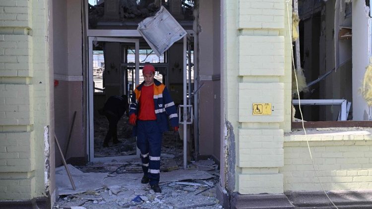 Um funcionário sai de uma estação de trem danificada após um ataque de drone na cidade de Lozova, região de Kharkiv, em 5 de agosto de 2025, em meio à invasão russa na Ucrânia. (Foto de Genya SAVILOV / AFP)