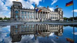 Deutscher Bundestag in Regenpfütze gespiegelt