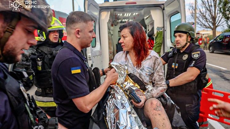 Esta fotografia, tirada e divulgada pelo Serviço de Emergência Ucraniano em 18 de agosto de 2025, mostra uma mulher ferida sendo levada para uma ambulância no local de um ataque, em Kharkiv, em meio à invasão russa da Ucrânia. Três pessoas morreram e mais de uma dúzia ficaram feridas em um ataque noturno de drones russos contra Kharkiv, na Ucrânia, informou o prefeito Igor Terekhov em 18 de agosto de 2025. (Photo by Handout / UKRAINIAN EMERGENCY SERVICE / AFP) 