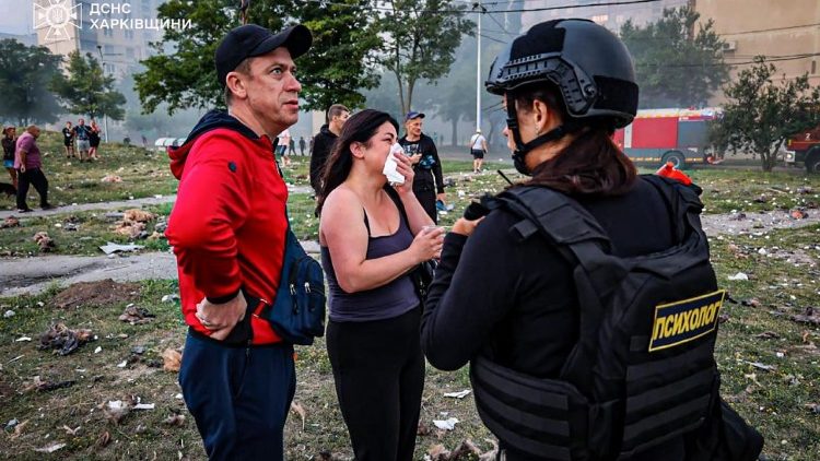 Esta fotografia, tirada e divulgada pelo Serviço de Emergência Ucraniano em 18 de agosto de 2025, mostra moradores reagindo no local de um ataque, em Kharkiv, em meio à invasão russa da Ucrânia. Três pessoas foram mortas e mais de uma dúzia ficaram feridas em um ataque noturno de drones russos contra Kharkiv, na Ucrânia, informou o prefeito Igor Terekhov em 18 de agosto de 2025. (Photo by Handout / UKRAINIAN EMERGENCY SERVICE / AFP) 