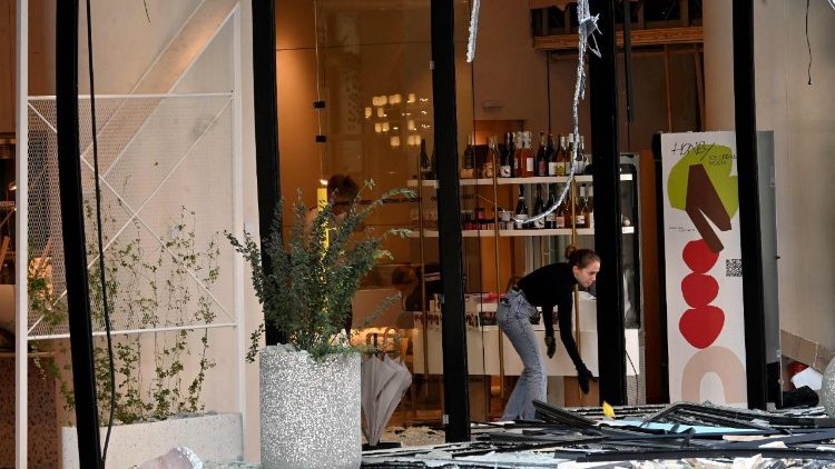 Um funcionário limpa os escombros em frente a um café nas áreas danificadas da capital ucraniana após um ataque em larga escala com drones e mísseis russos em Kiev, em 28 de agosto de 2025, em meio à invasão russa da Ucrânia. (Foto de Sergei SUPINSKY / AFP)