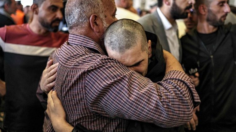 हमास द्वारा छोड़े गये 20 इस्राएली कैदियों में से एक अपने परिजन को गले लगाते हुए