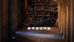 A man sleeps in a sleeping bag next to a cafe on 15 October 2025