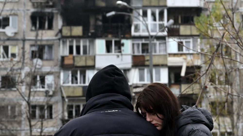 A reação de moradores em frente a um prédio residencial danificado após um ataque aéreo em Kiev, em 29 de novembro de 2025, em meio à invasão russa na Ucrânia. Um ataque de drone russo atingiu a capital ucraniana nas primeiras horas de 29 de novembro de 2025, matando uma pessoa e ferindo sete, disseram as autoridades de Kiev. (Foto de Genya SAVILOV / AFP)