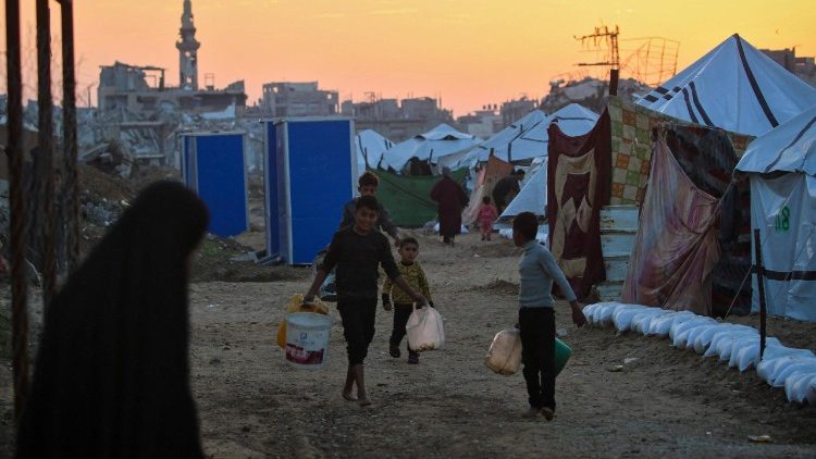 Children carry water in the Nuseirat camp for displaced Palestinians in the central Gaza Strip