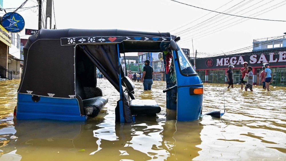 Um riquixá motorizado está preso enquanto pessoas atravessam uma rua alagada após fortes chuvas em Wellampitiya, nos arredores de Colombo, em 30 de novembro de 2025. Tempestades tropicais e chuvas de monção atingiram o Sudeste e o Sul da Ásia neste mês, provocando deslizamentos de terra e enchentes repentinas desde as florestas tropicais da ilha de Sumatra, no oeste da Indonésia, até as plantações nas terras altas do Sri Lanka. (Foto de Ishara S. KODIKARA / AFP)