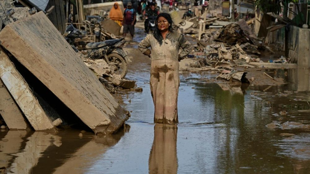 Uma mulher coberta de lama está em uma rua alagada após uma enchente repentina atingir a região de Aceh Tamiang, província de Aceh, em 6 de dezembro de 2025. Tempestades tropicais e chuvas de monção atingiram o Sudeste e o Sul da Ásia neste mês, provocando deslizamentos de terra e enchentes repentinas desde as florestas tropicais da ilha de Sumatra, no oeste da Indonésia, até as plantações nas terras altas do Sri Lanka. (Foto de YT HARIONO / AFP)
