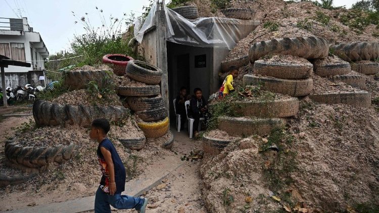 Children play around a bunker in Surin province on December 10, 2025, during clashes along the Thai-Cambodia border.