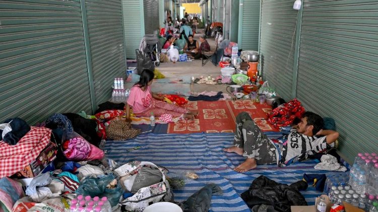 People rest at a temporary camp for displaced people set up at a former market in Banteay Meanchey province