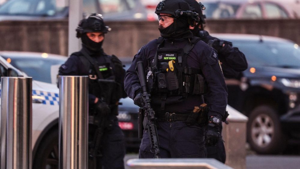 Policiais armados atuam no local após um tiroteio na praia de Bondi, em Sydney, em 14 de dezembro de 2025. A polícia australiana informou que duas pessoas foram detidas após relatos de múltiplos disparos em 14 de dezembro na famosa praia de Bondi, em Sydney, e pediu à população que se abrigasse. (Foto de DAVID GRAY / AFP)