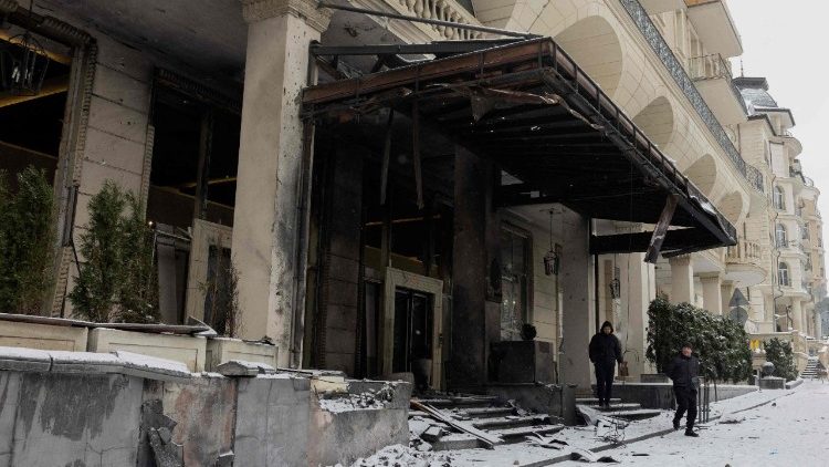 Homens observam um complexo residencial danificado ap&oacute;s um ataque russo perto da embaixada do Catar na Ucr&acirc;nia, em Kiev, na madrugada de 9 de janeiro de 2026, em meio &agrave; invas&atilde;o russa da Ucr&acirc;nia. A R&uacute;ssia lan&ccedil;ou um ataque massivo contra a capital ucraniana, incendiando pr&eacute;dios de apartamentos e matando pelo menos quatro pessoas, informou a pol&iacute;cia de Kiev em 9 de janeiro de 2026, ap&oacute;s Moscou rejeitar o mais recente plano de paz p&oacute;s-guerra. (Foto de Tetiana DZHAFAROVA / AFP)