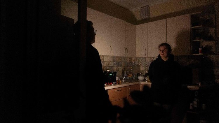 Evgenia e seu marido Pavlo, moradores locais, conversam na cozinha com uma lanterna durante um apag&atilde;o em Kiev, na noite de 13 de janeiro de 2026, em meio &agrave; invas&atilde;o russa da Ucr&acirc;nia. (Foto de Tetiana DZHAFAROVA / AFP)
