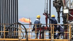 Employees work with pipelines during the extraction of crude oil at a plant of Colombian petroleum company