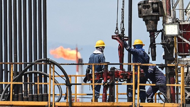Employees work with pipelines during the extraction of crude oil at a plant of Colombian petroleum company