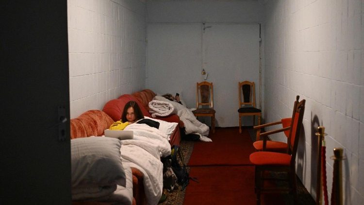 Pessoas deitadas em sof&aacute;s no abrigo subterr&acirc;neo do hotel durante um ataque a&eacute;reo em Kiev, na madrugada de 24 de janeiro de 2026, em meio &agrave; invas&atilde;o russa da Ucr&acirc;nia. (Foto de Sergei Gapon / AFP)