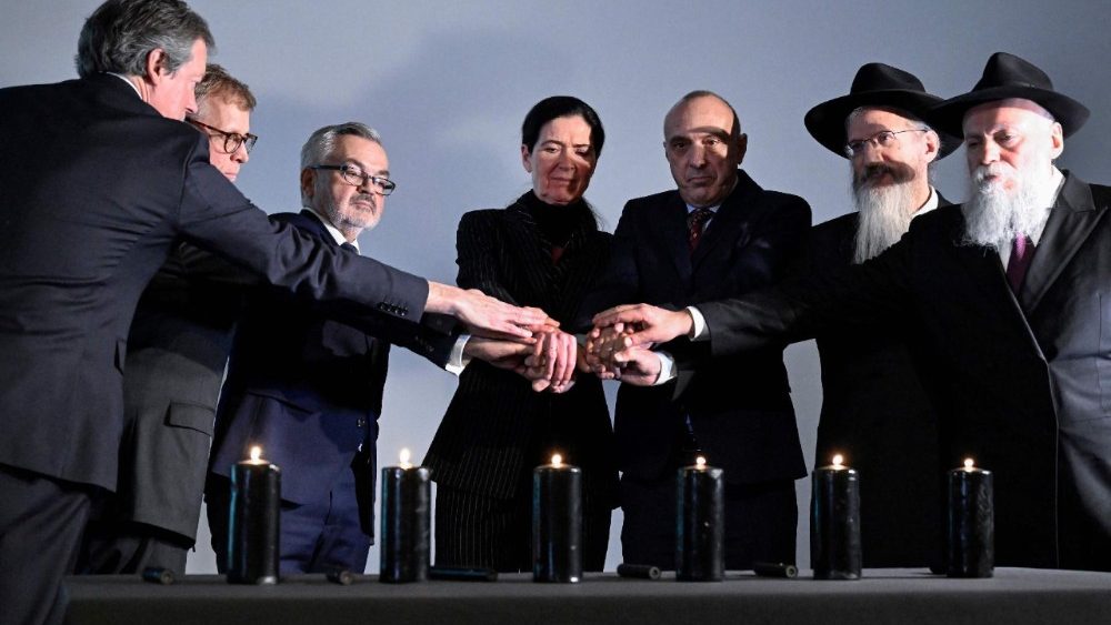 People light candles during a ceremony marking International Holocaust Remembrance Day
