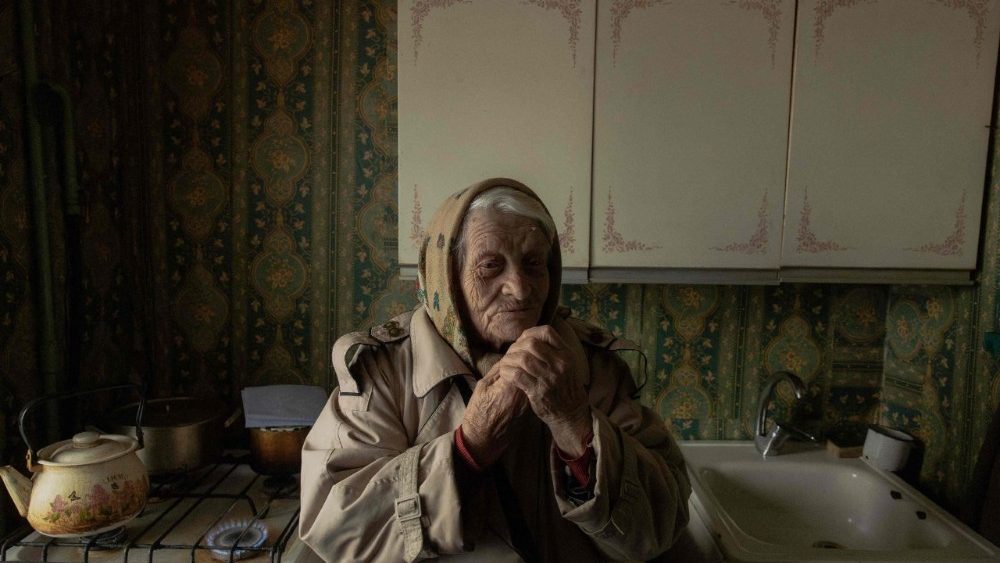 Yevheniia Yeremina, uma aposentada de 89 anos, está em sua cozinha usando um fogão a gás para aquecer seu apartamento, que não tem eletricidade nem aquecimento, em Kiev, em 26 de janeiro de 2026, após ataques com mísseis e drones à infraestrutura energética ucraniana em meio à invasão russa na Ucrânia. A Rússia intensificou neste mês seus ataques contra a infraestrutura de energia e aquecimento da Ucrânia, mergulhando os moradores de Kiev na escuridão e no frio, com temperaturas chegando a -20°C. (Foto de Roman PILIPEY / AFP)