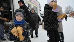 Trẻ em Ucraina nhận bánh mì được phân phát cho người di cư