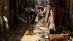 Um homem limpa uma rua coberta de lama no município de Ubá, no estado de Minas Gerais, Brasil, após o rio Ubá transbordar devido às fortes chuvas.