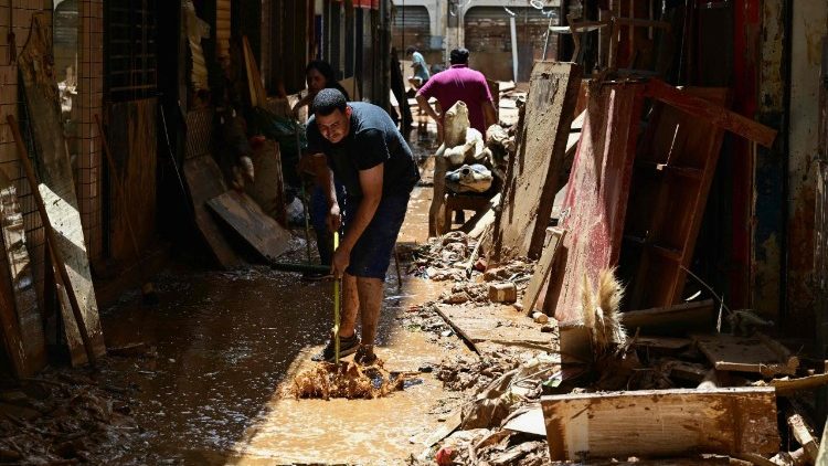Um homem limpa uma rua coberta de lama no município de Ubá, no estado de Minas Gerais, Brasil, após o rio Ubá transbordar devido às fortes chuvas.