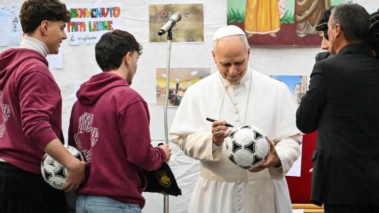 Papst Leo signiert einen Fussball f&uuml;r die Jugendlichen des Viertels