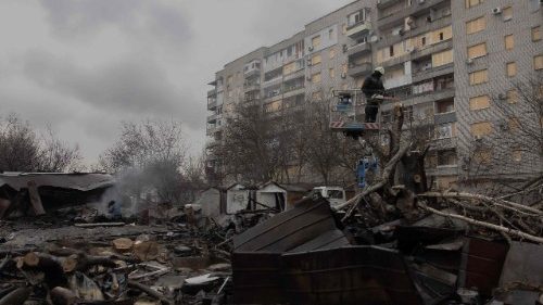 FILE PHOTO: A Ukrainian municipal worker cuts down a tree at the site of a recent Russian air attack in front of a damaged residential building in Zaporizhzhia