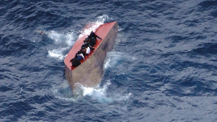Migrants seated on a capsized boat off Libya