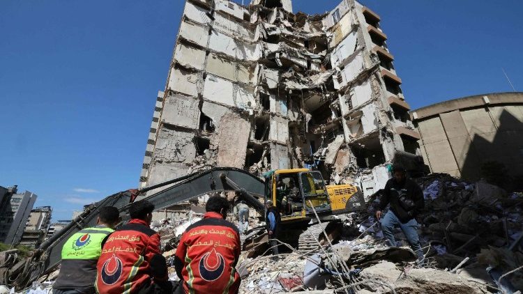 Lebanese rescuers clear the rubble at the site of an Israeli airstrike that targeted a building on April 8 in Beirut