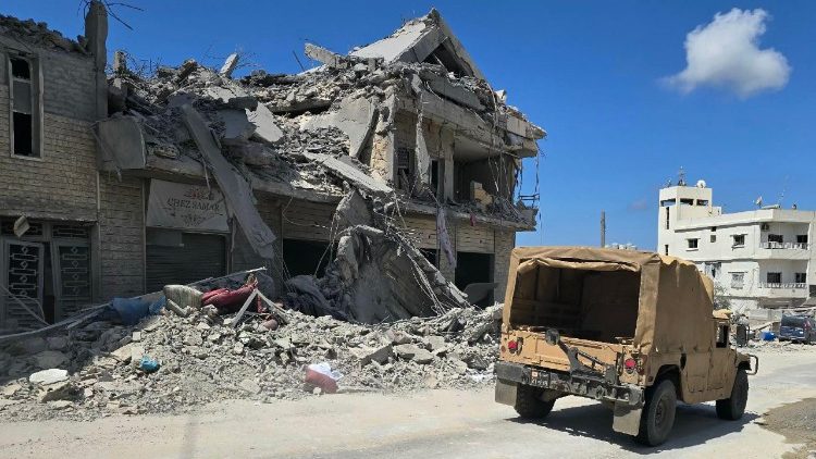 Une jeep passe ce 12 avril devant un bâtiment détruit par une frappe israélienne qui a visé le village d'Al-Bazouriyah, dans le sud du Liban.