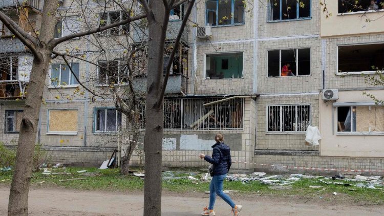 Uma mulher caminha ao lado de um pr&eacute;dio residencial danificado ap&oacute;s um ataque russo em Kiev, em 16 de abril de 2026, em meio &agrave; invas&atilde;o russa da Ucr&acirc;nia. Ataques russos massivos contra a Ucr&acirc;nia deixaram pelo menos 19 mortos durante a noite de 15 para 16 de abril, principalmente em Kiev e Odessa, disseram as autoridades ucranianas em 16 de abril de 2026, descrevendo esses ataques como alguns dos mais mortais das &uacute;ltimas semanas. (Foto de Tetiana DZHAFAROVA / AFP)