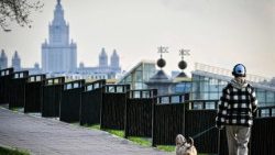 Uma menina passeia com um cachorro em frente à Universidade Estatal de Moscou em 16 de abril de 2026. (Foto de Alexander NEMENOV / AFP)