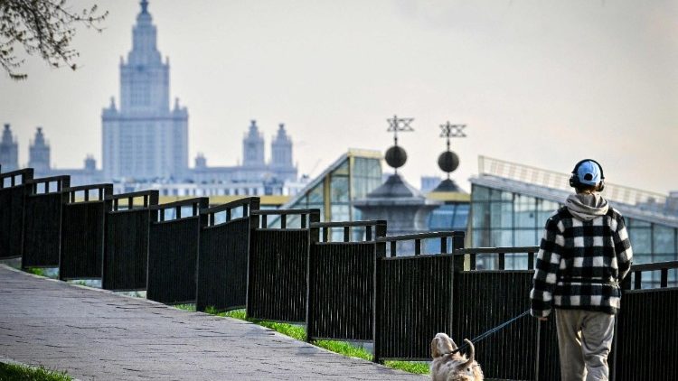 Uma menina passeia com um cachorro em frente à Universidade Estatal de Moscou em 16 de abril de 2026. (Foto de Alexander NEMENOV / AFP)