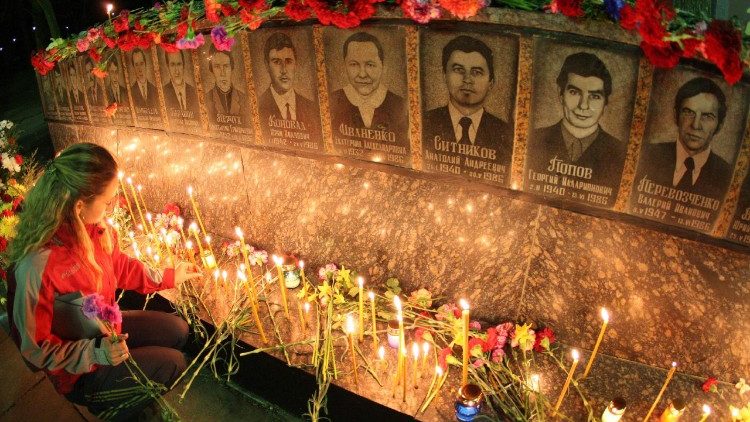 स्लावतिक में चेर्नोबिल के पीड़ितों के लिए बने स्मारक पर फूल और मोम बत्तियाँ